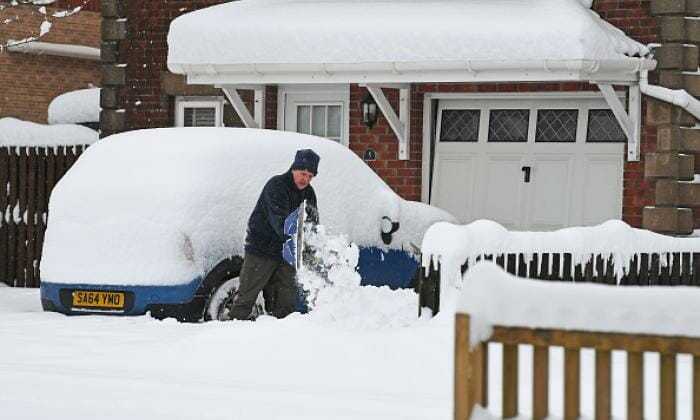 Man Shovelling Snow in His Drive