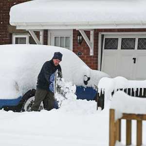 Man Shovelling Snow in His Drive