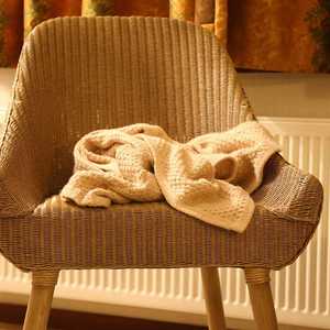 Wooden Chair with Blanket in Front of Radiator