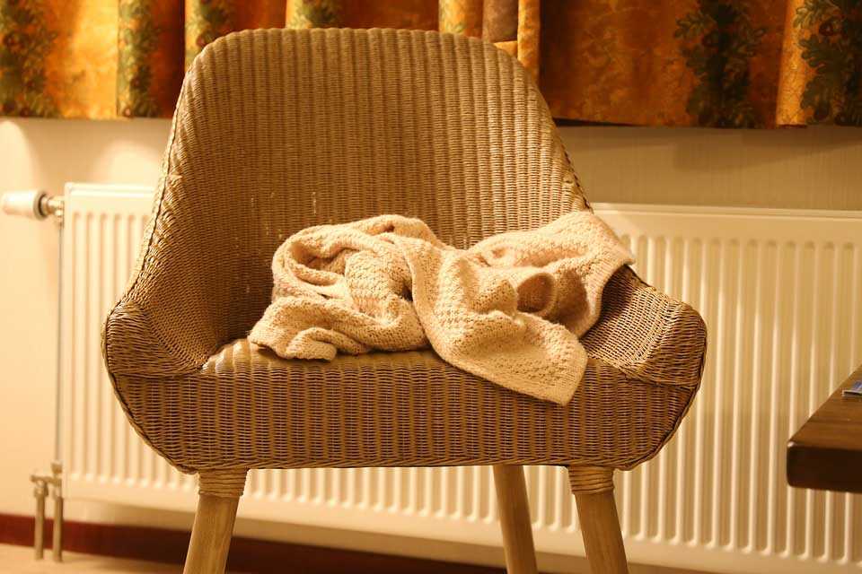 Wooden Chair with Blanket in Front of Radiator