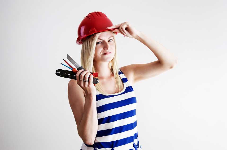Woman Weating Red Helmet and Holding Tools