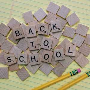 Back to School Written in Wooden Squares on Top of Yellow Lined Paper