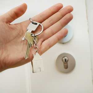 Person Holding Keys to Door