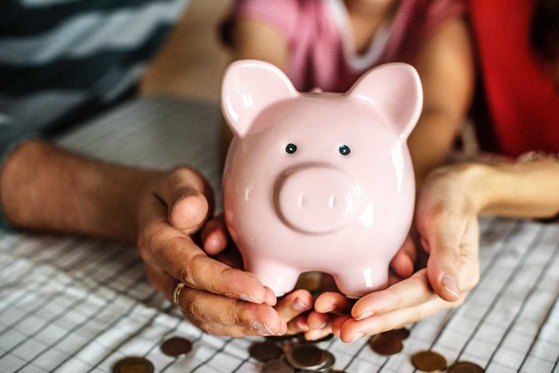 Family Holding Piggy Bank Spilling Money