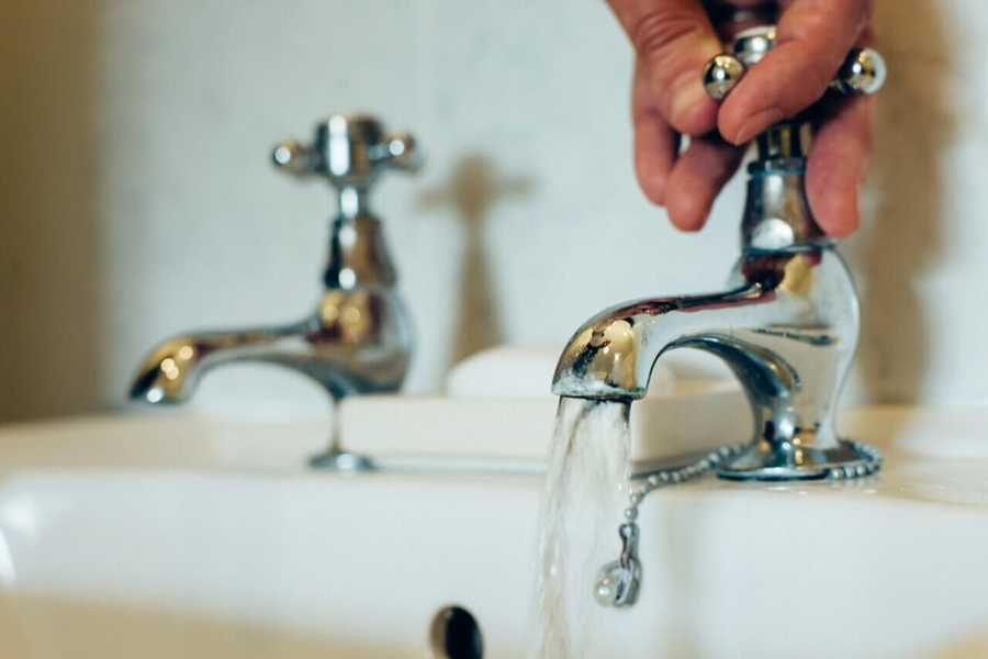 Tap with Water Running into The Sink