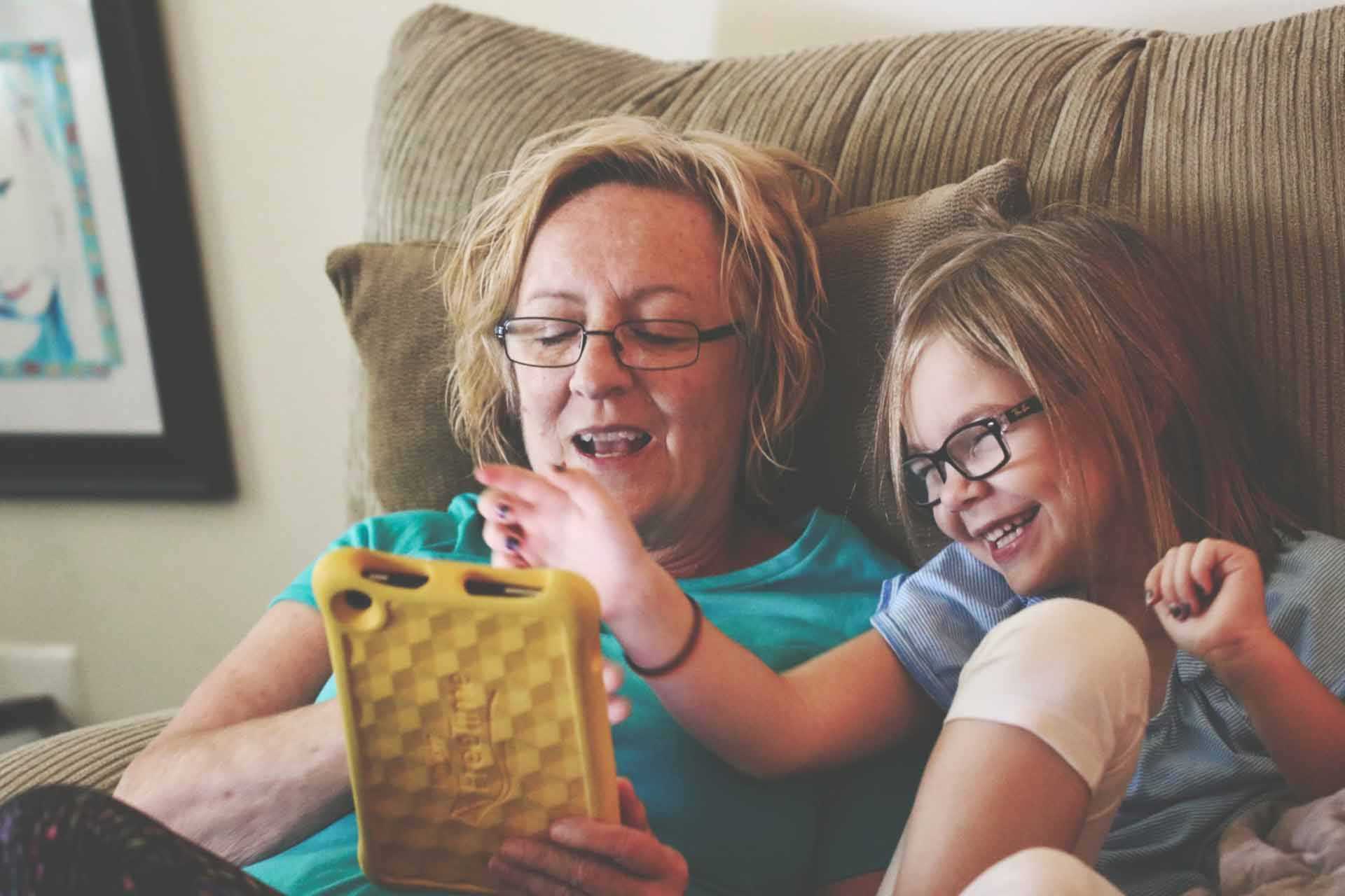 Mother and Child Playing on Tablet and Laughing