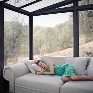 Woman Sleeping on Sofa in Conservatory
