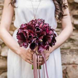 Bride Holding Bouquet Next to Stone Wall
