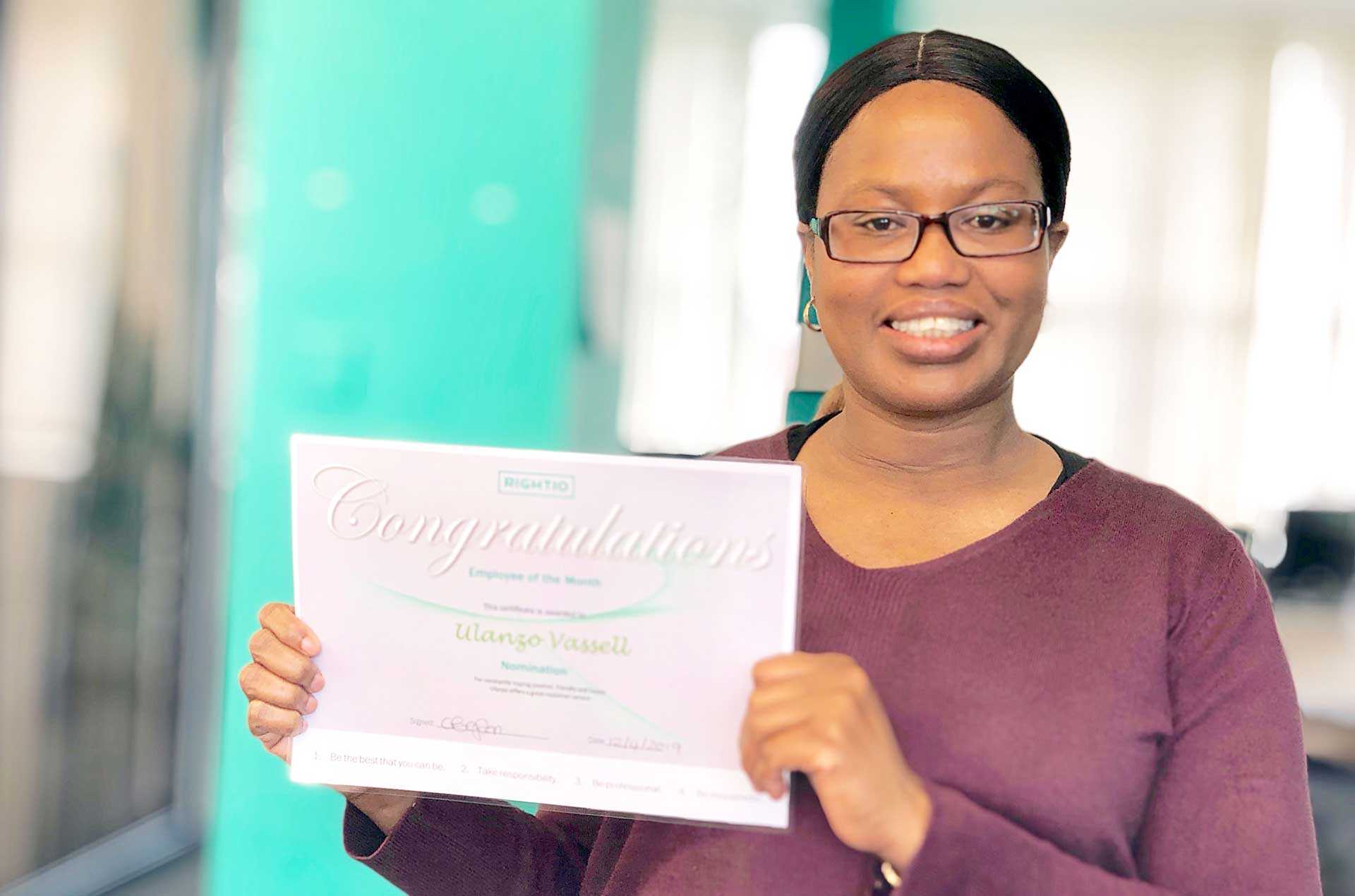 Ulanzo Vassell Holding Employee of The Month Certificate