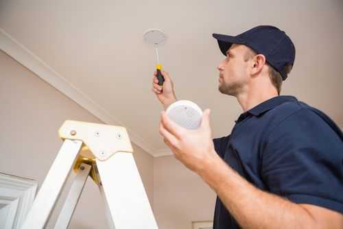 Engineer Installing Smoke Alarm