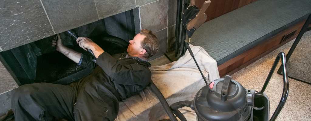 man lying down cleaning a chimney