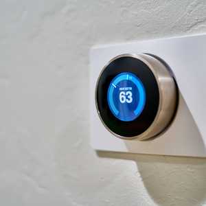 Thermostat on White Wall Showing 63